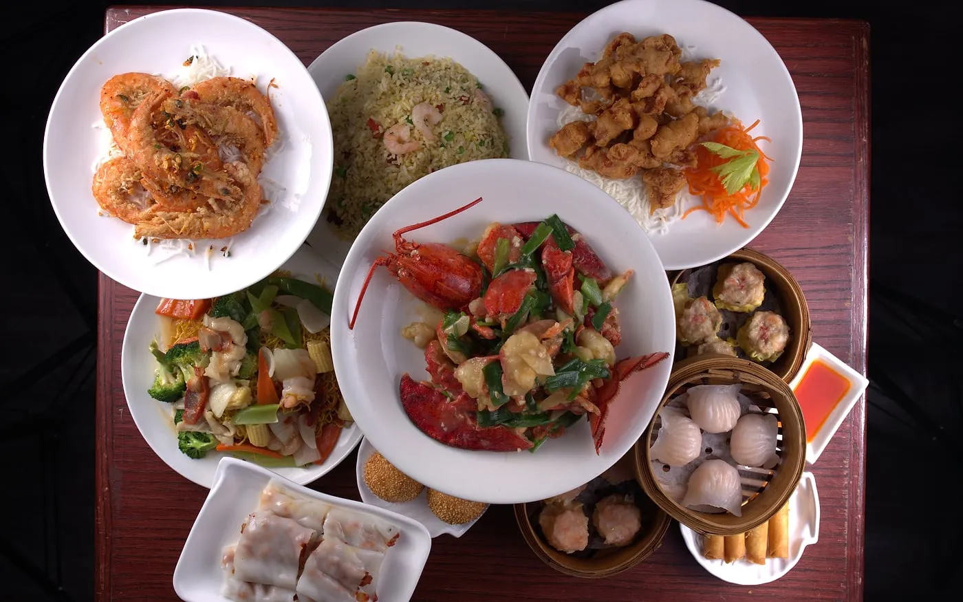 Ng's Cuisine table spread with noodles, greens, chicken, and bamboo steamers for shared dining