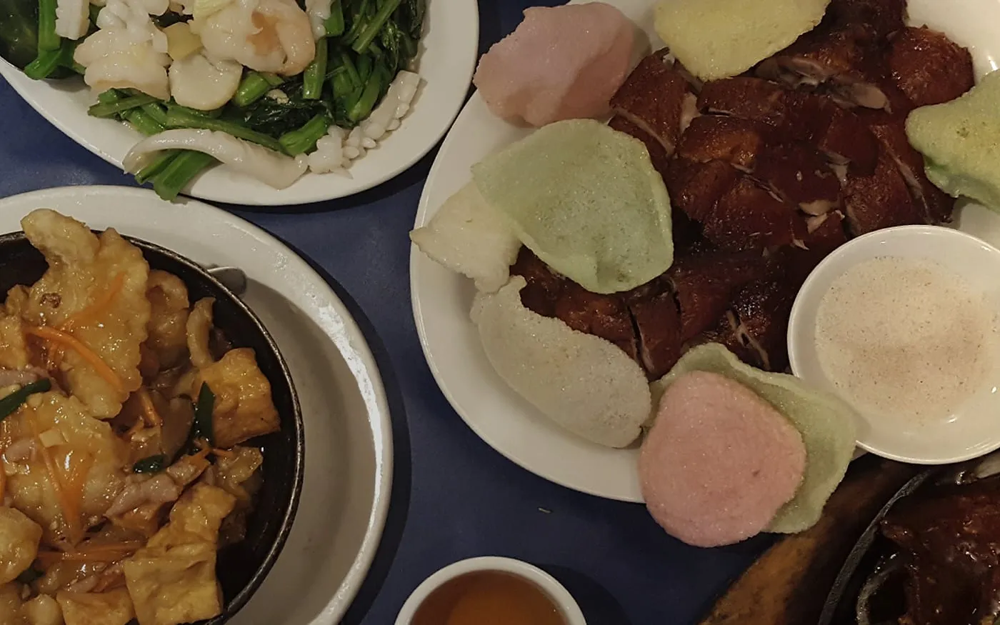 Royal Treasure shared Chinese dinner with roast meats, greens, rice, and sauced dishes on a blue table