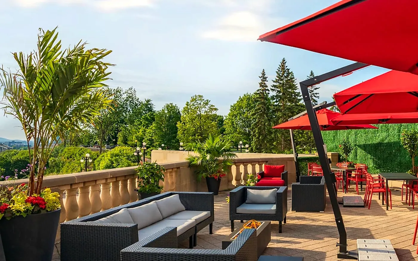 La Terrasse outdoor seating with red umbrellas, greenery, and Ottawa terrace views