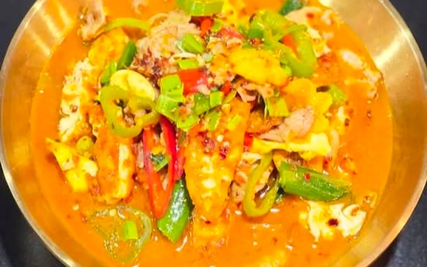 Papa Spicy chilli-heavy fish dish with peppers and orange-red sauce