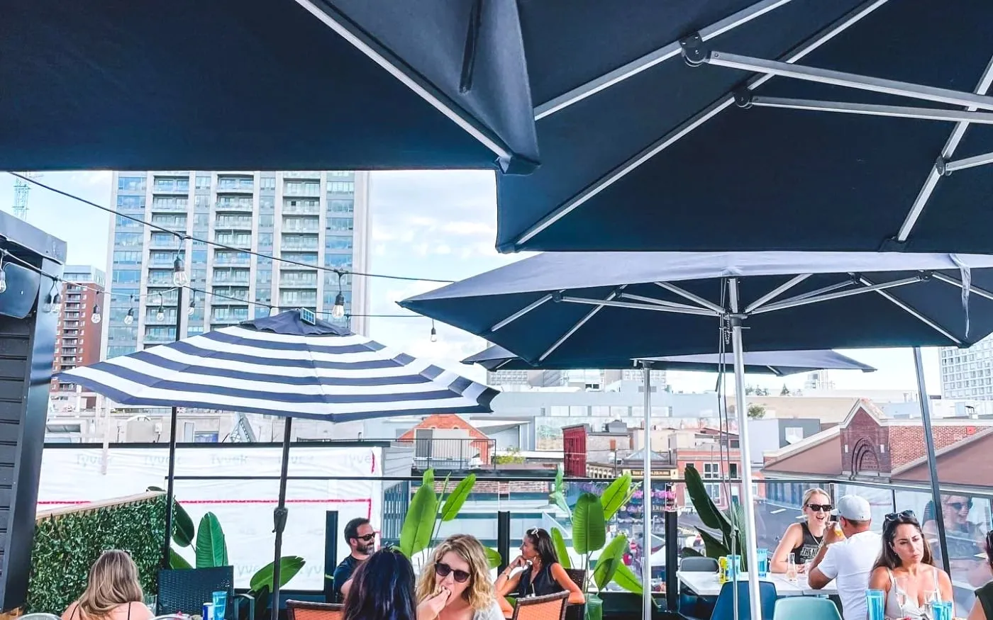Rooftop Ottawa patio with umbrellas, guests, and downtown ByWard Market views