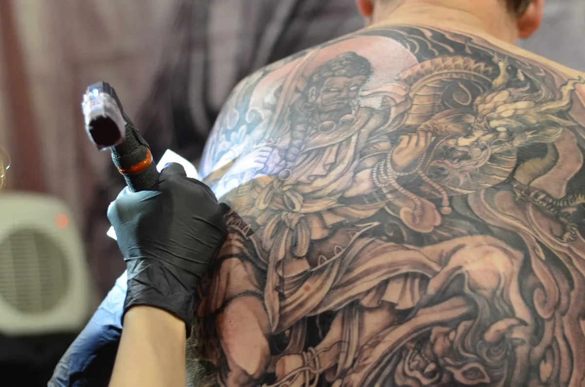 Tattoo artist working on detailed piece