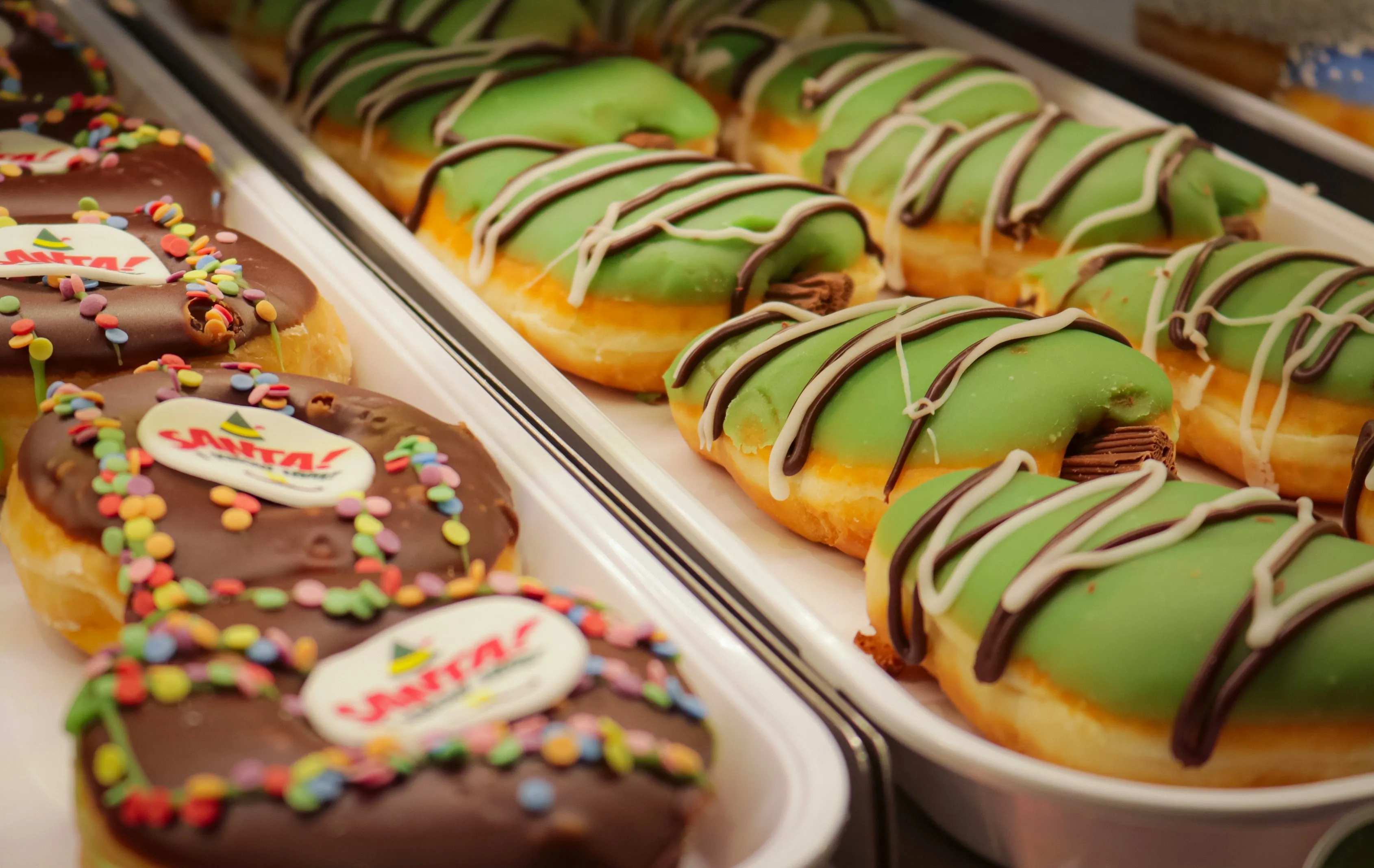 Colorful donuts in a display case with bright glazes and toppings