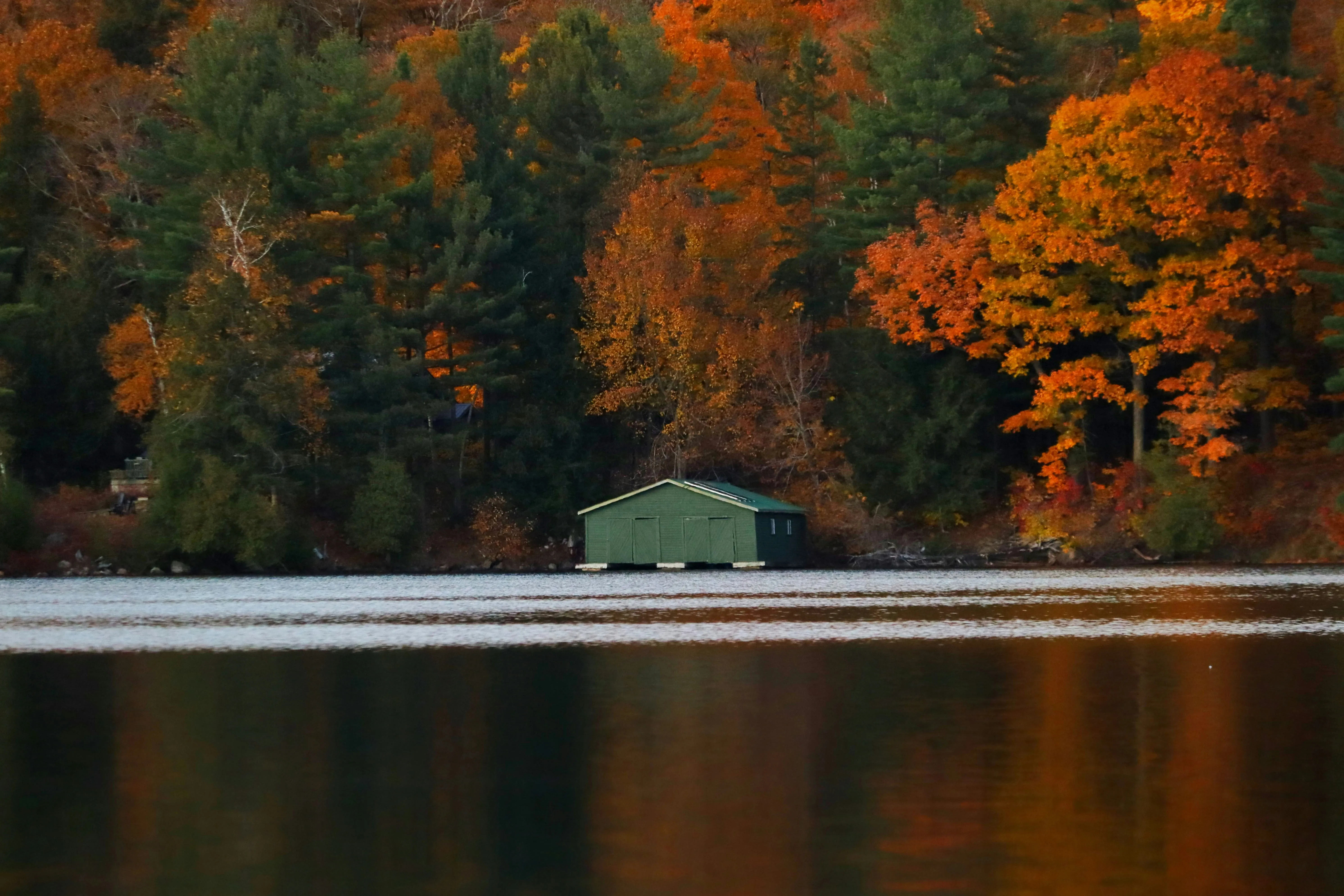 Cabin on a lake surrounded by autumn forest in Gatineau Park Quebec