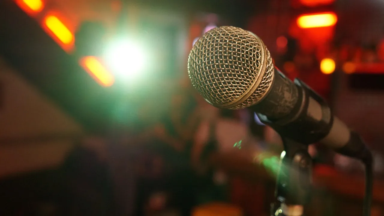 Microphone on a lit comedy stage with dramatic lighting