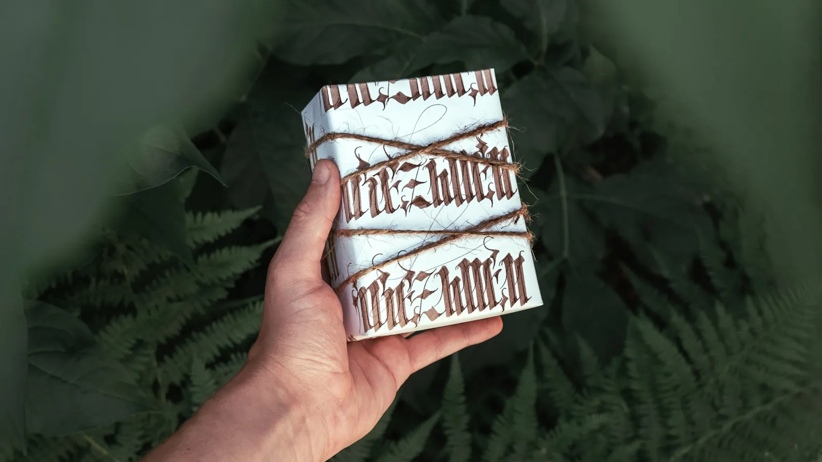 Hands wrapping gifts on a table