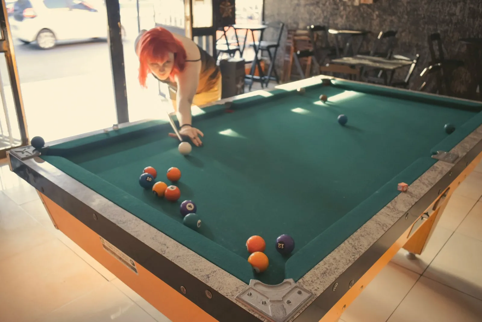 Players lining up a shot on a pool table