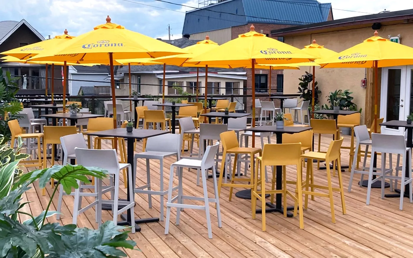 The Porch on Preston rooftop deck with bright yellow umbrellas and open-air group seating