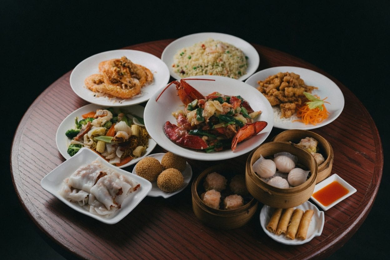 Ng's Cuisine table spread with noodles, greens, chicken, and bamboo steamers for shared dining
