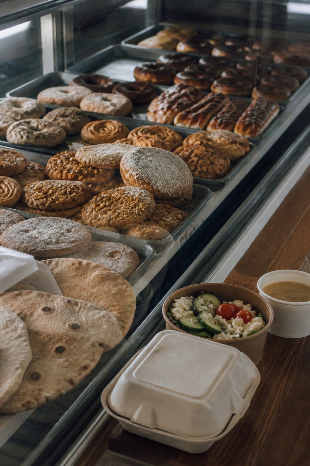 Mediterranean bakery counter with flatbreads, pastries, and takeaway lunch items