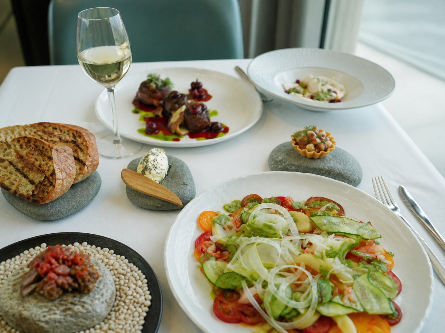 Mediterranean table contrasting casual grill plates with upscale plated seafood
