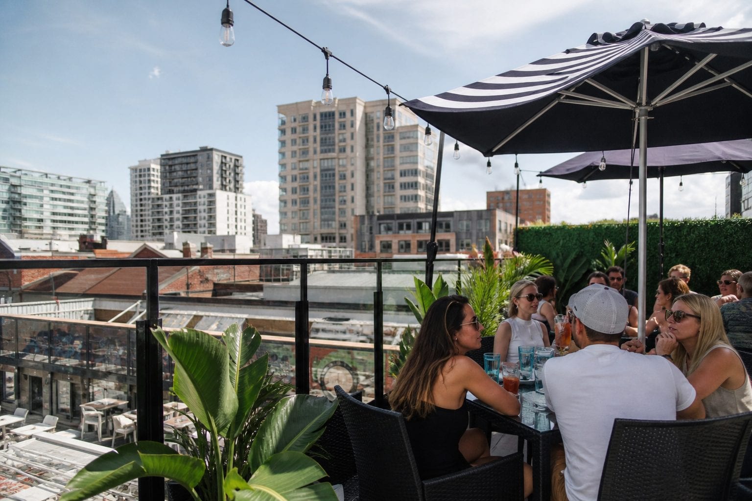 Rooftop Ottawa patio with umbrellas, guests, and downtown ByWard Market views