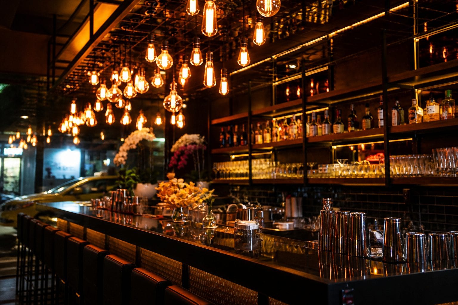 Warm-lit Westboro bar interior with bottles and hanging lights