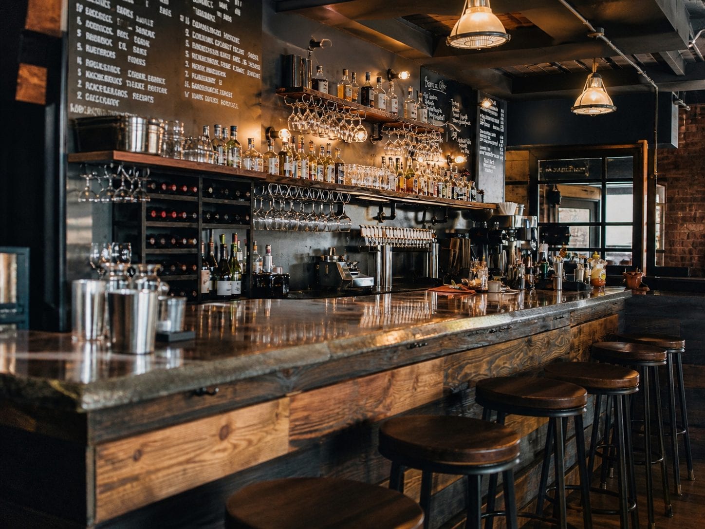 Busy pub bar interior with bottles and stools
