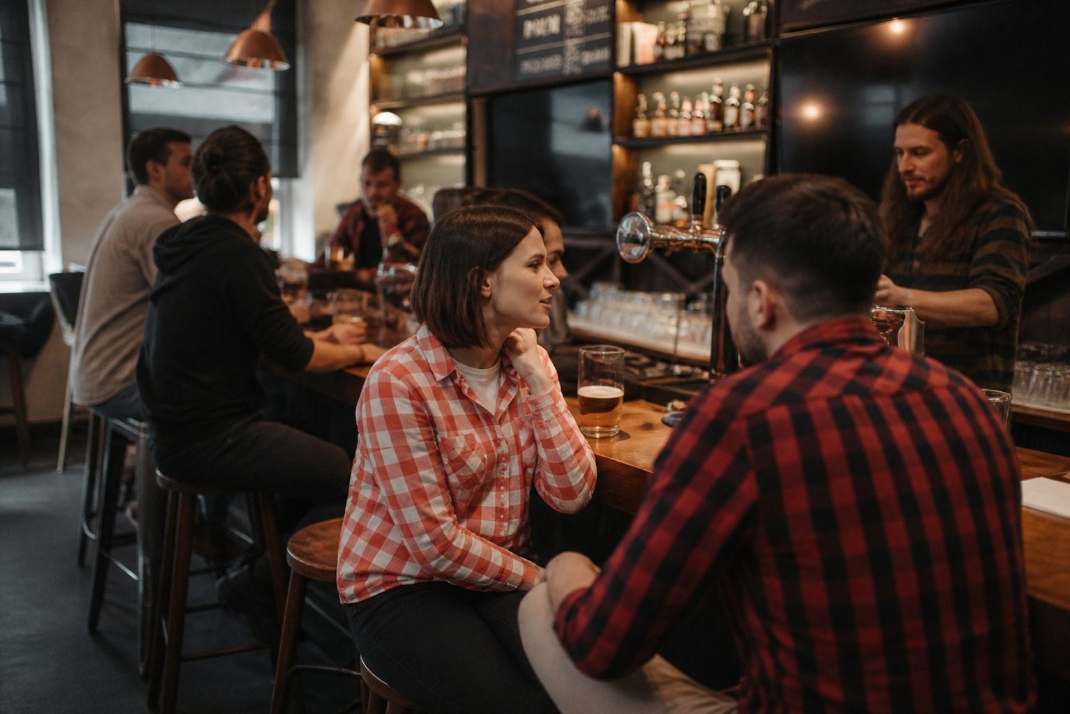 Neighbourhood pub bar with seated patrons and draft taps