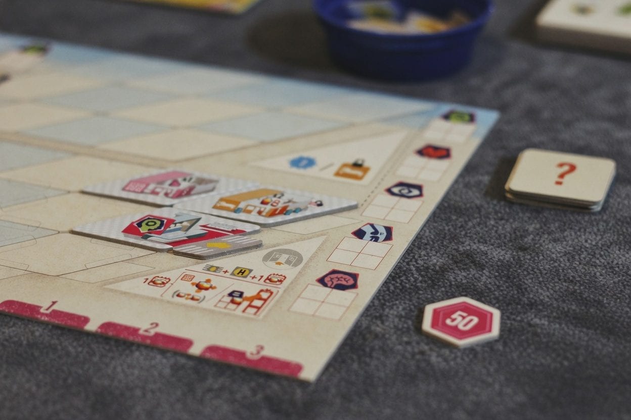 Board game tiles and tokens laid out on a table
