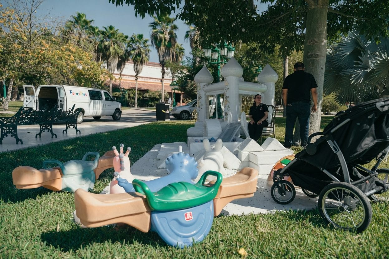 Delivery van unloading an inflatable at a backyard party