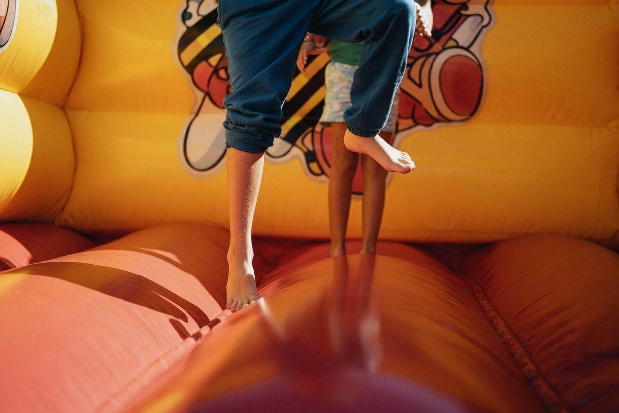 Kids playing in a bright inflatable bounce house
