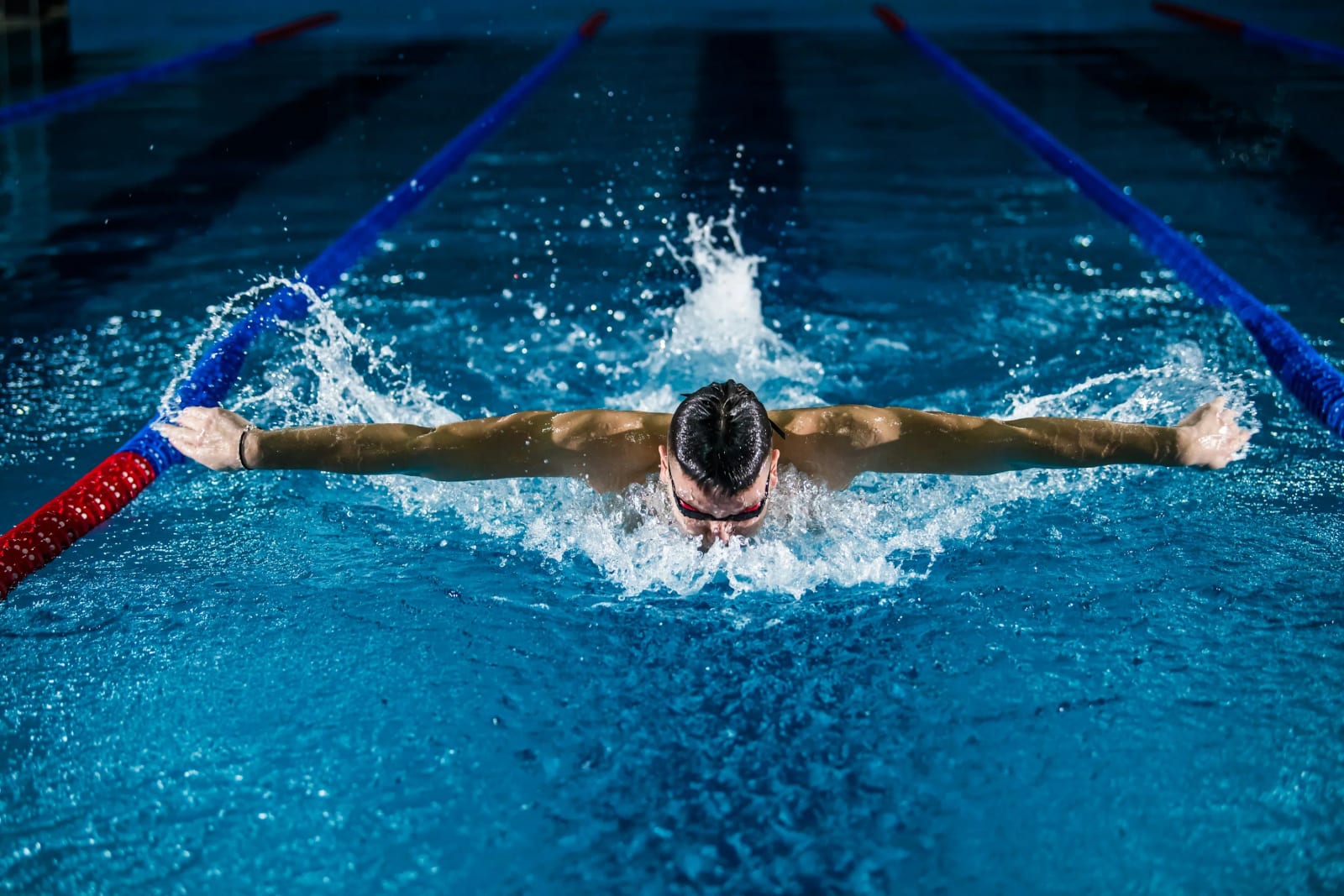 Olympic swimmer diving into the pool during competition.