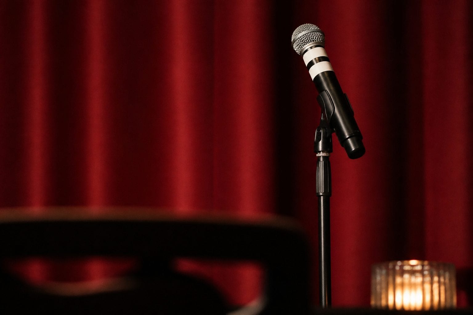 Stand-up comedy stage with microphone on red curtain