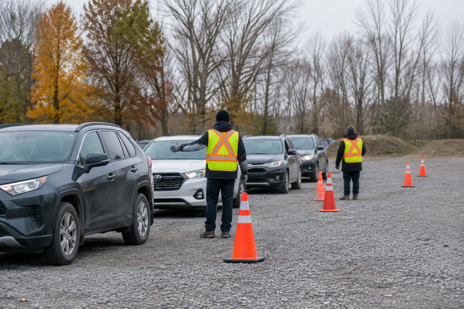 Rows of paint cans and household cleaners lined up for drop-off at an outdoor collection event