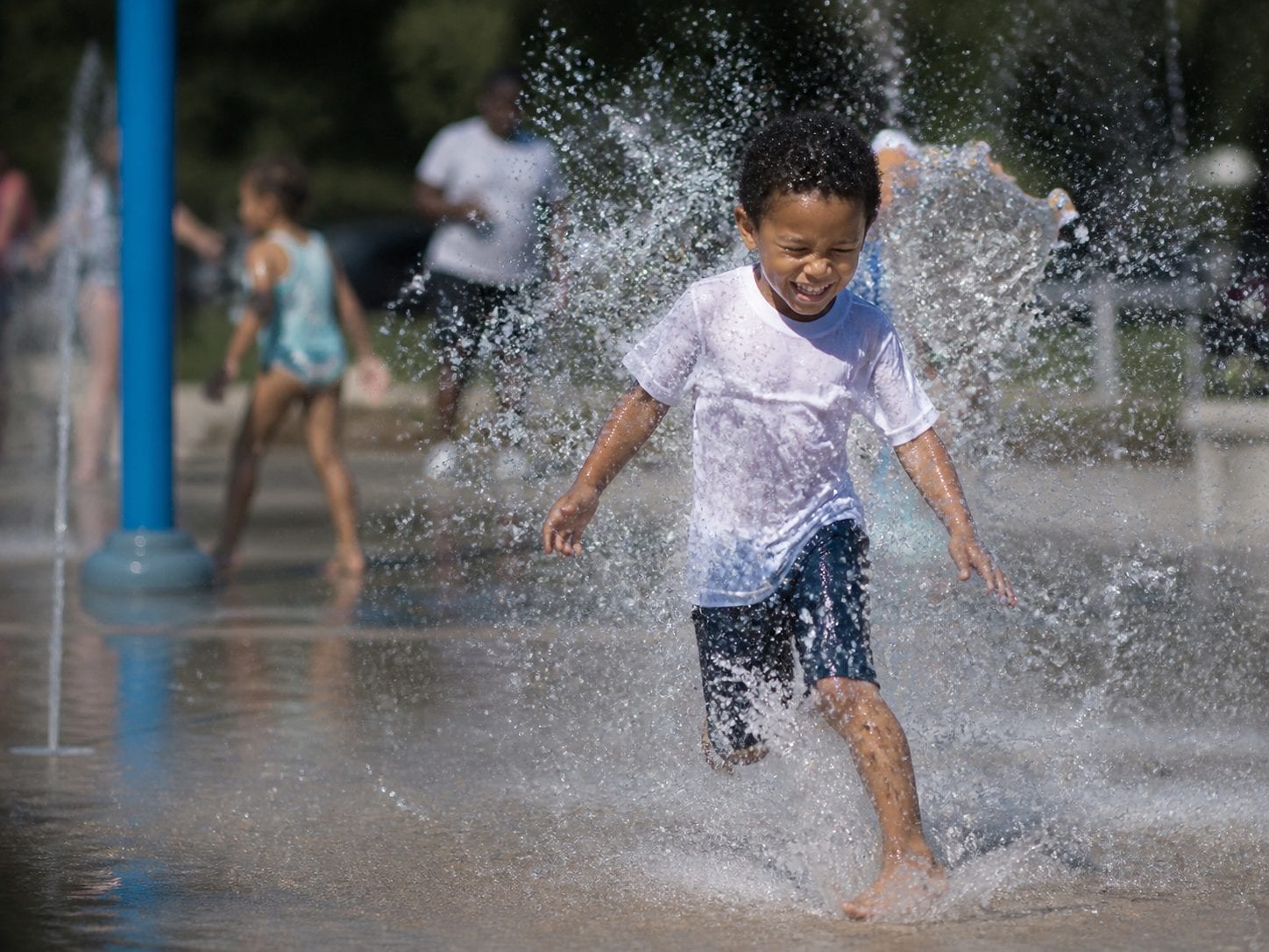 Children cooling off at an outdoor splash pad in summer