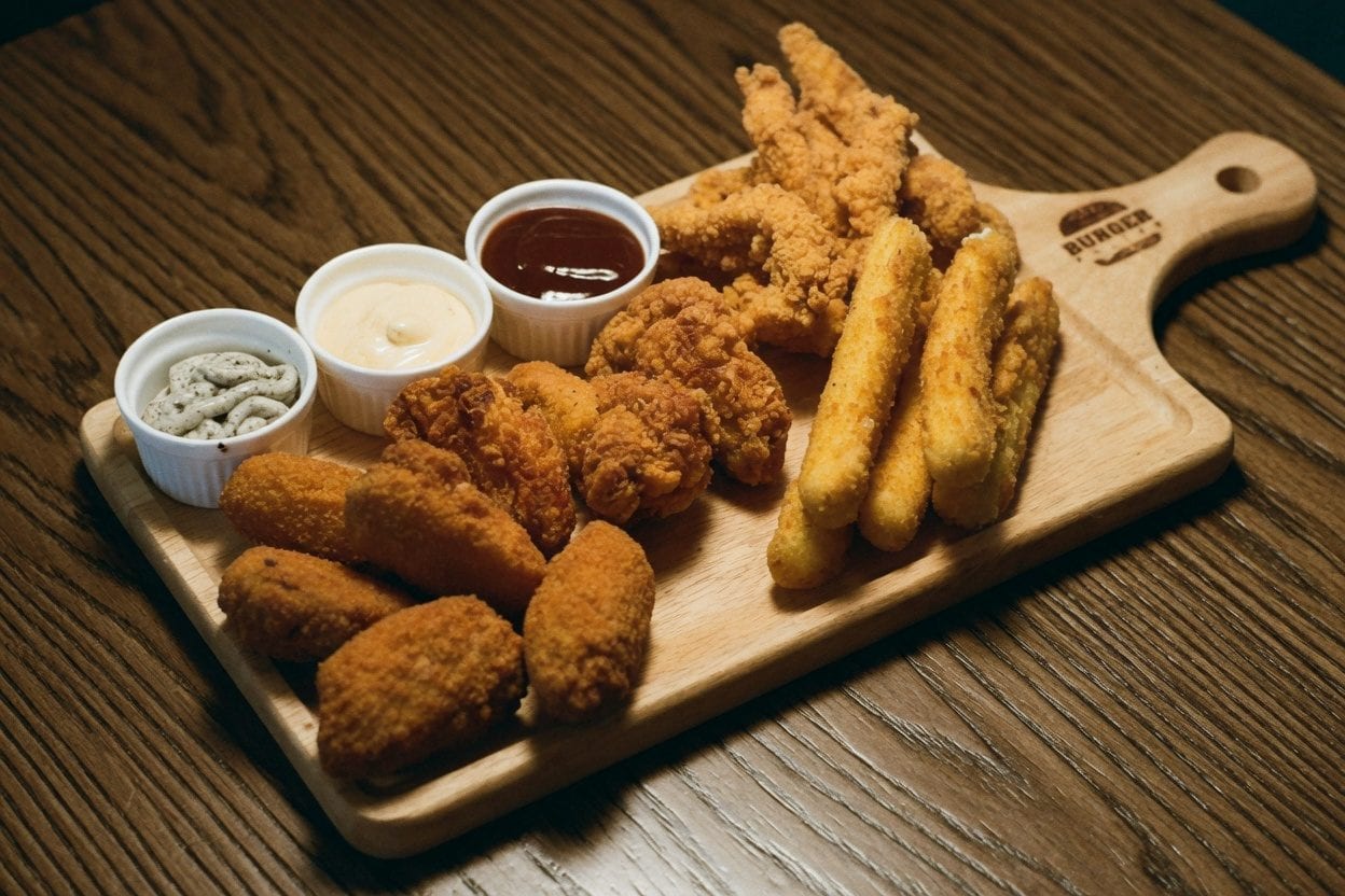Hands sharing fried chicken