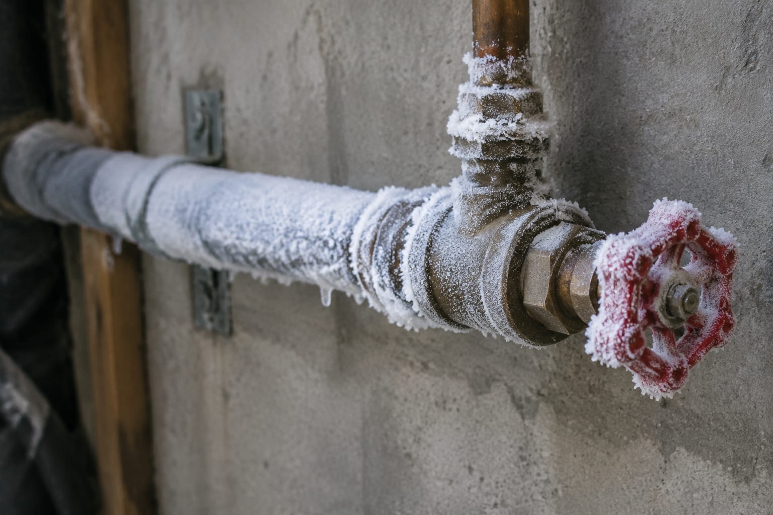 A copper water pipe coated in frost beside a basement wall in an Ottawa home