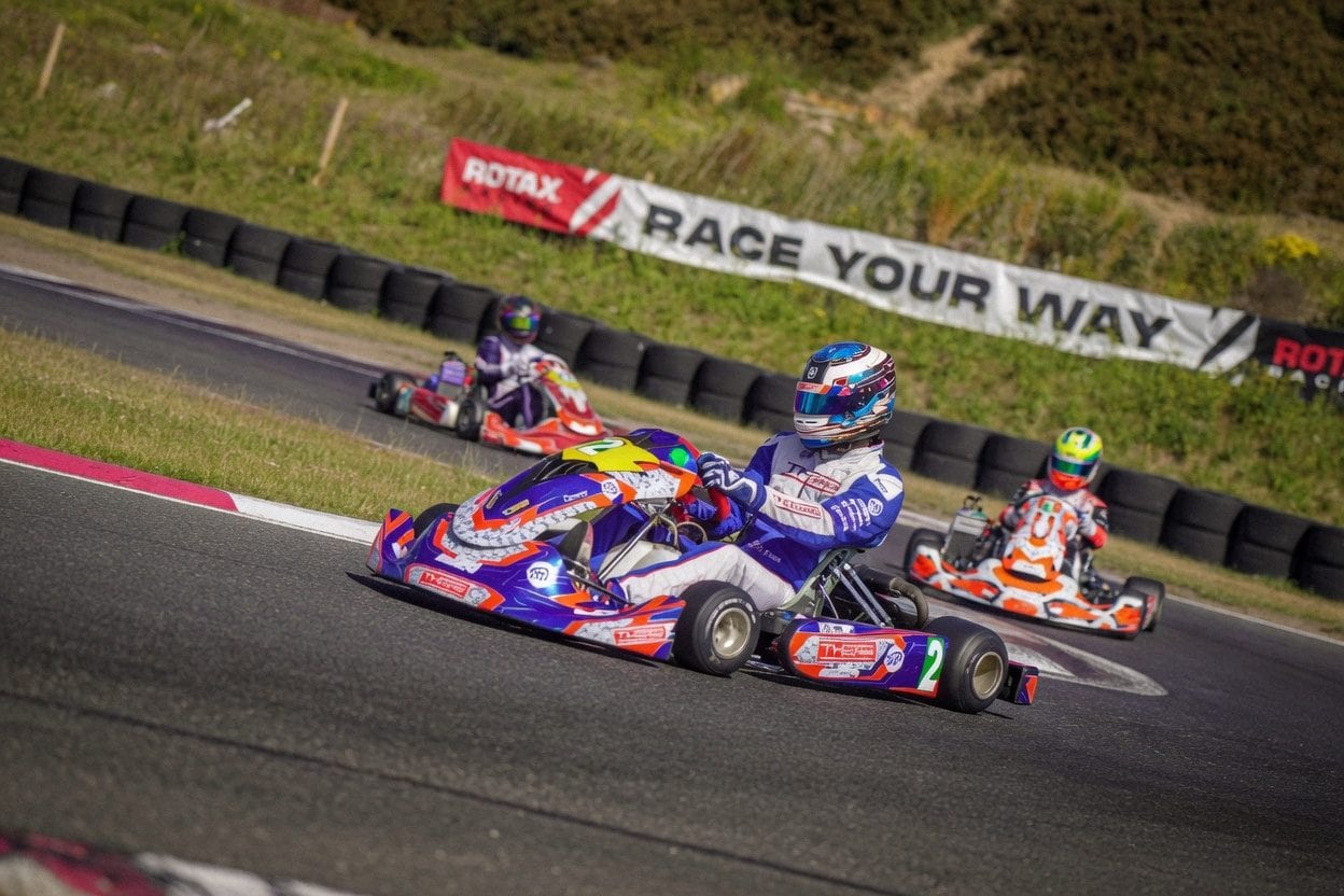 Children in junior go karts with safety gear and instructors