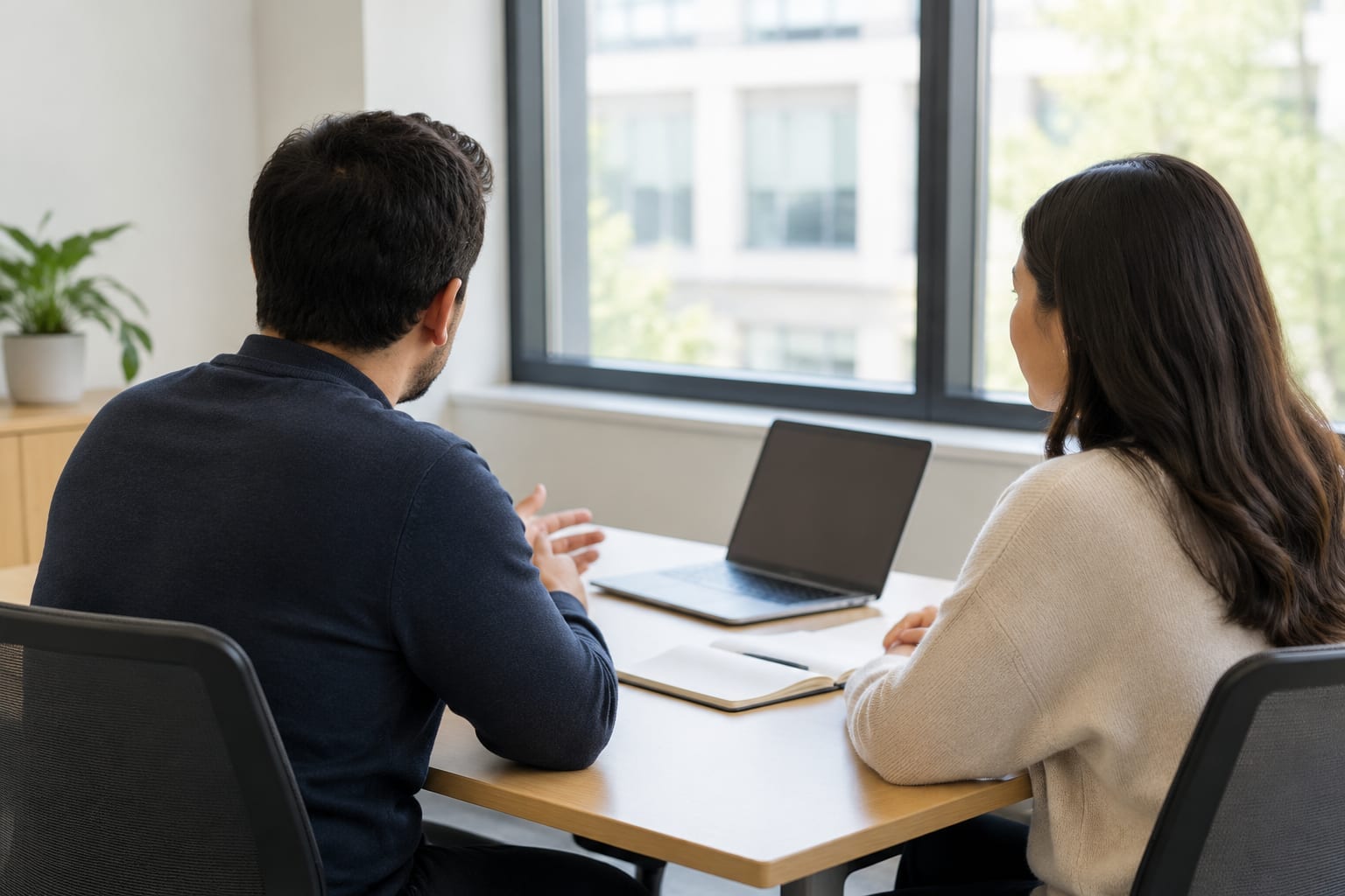 An advisor and a small business owner talking across a table in a bright Ottawa meeting room