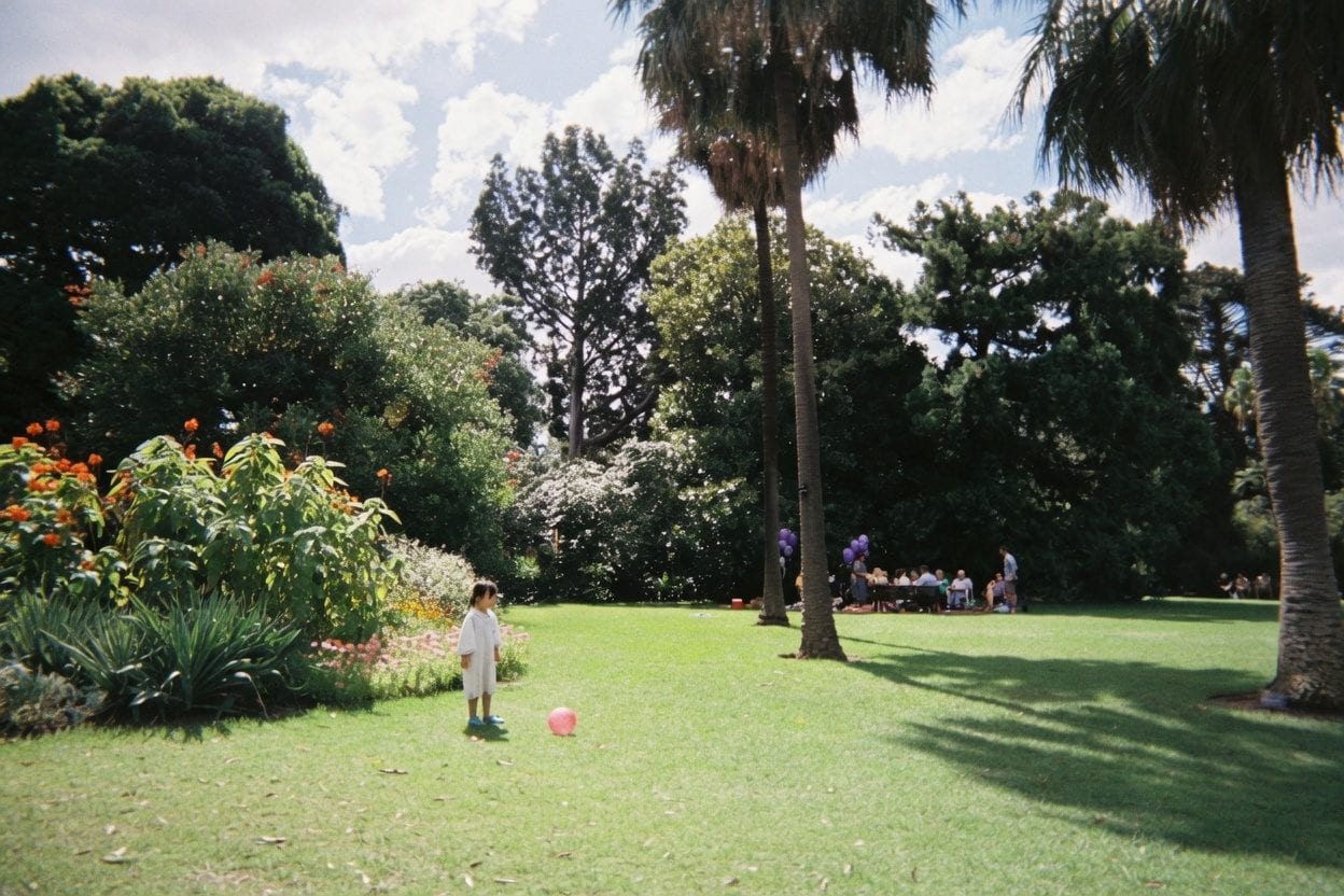 Kids running through a field at an outdoor party