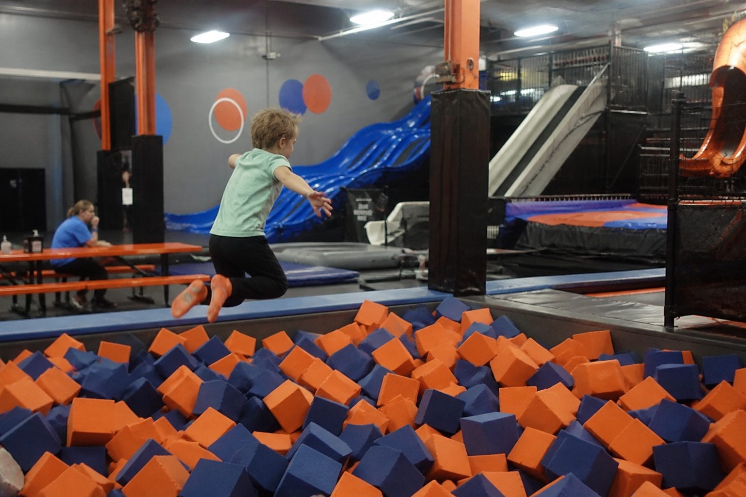 Kids jumping into a foam pit at a trampoline park