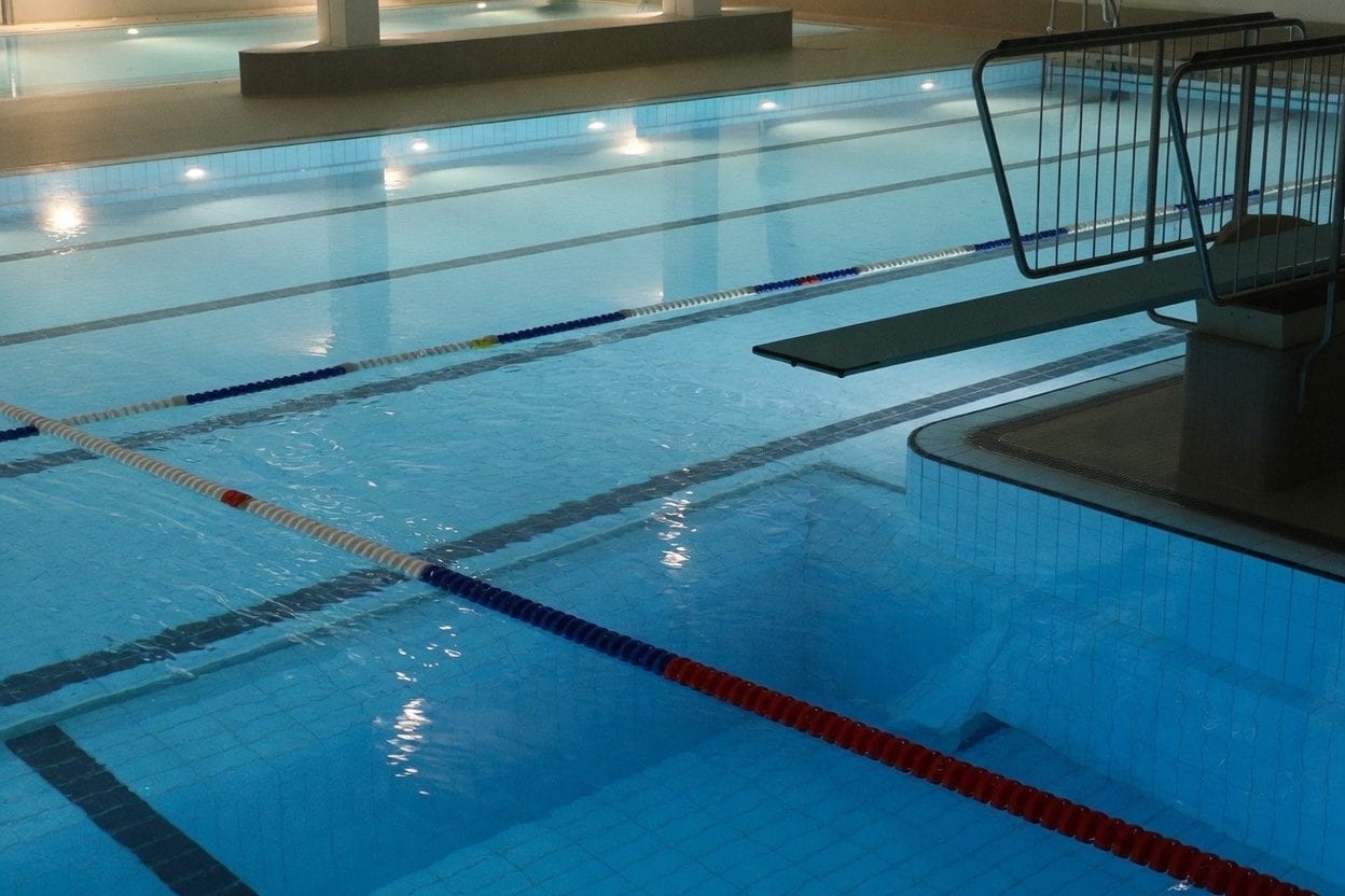 Indoor pool setting aligned with full-service gym amenities
