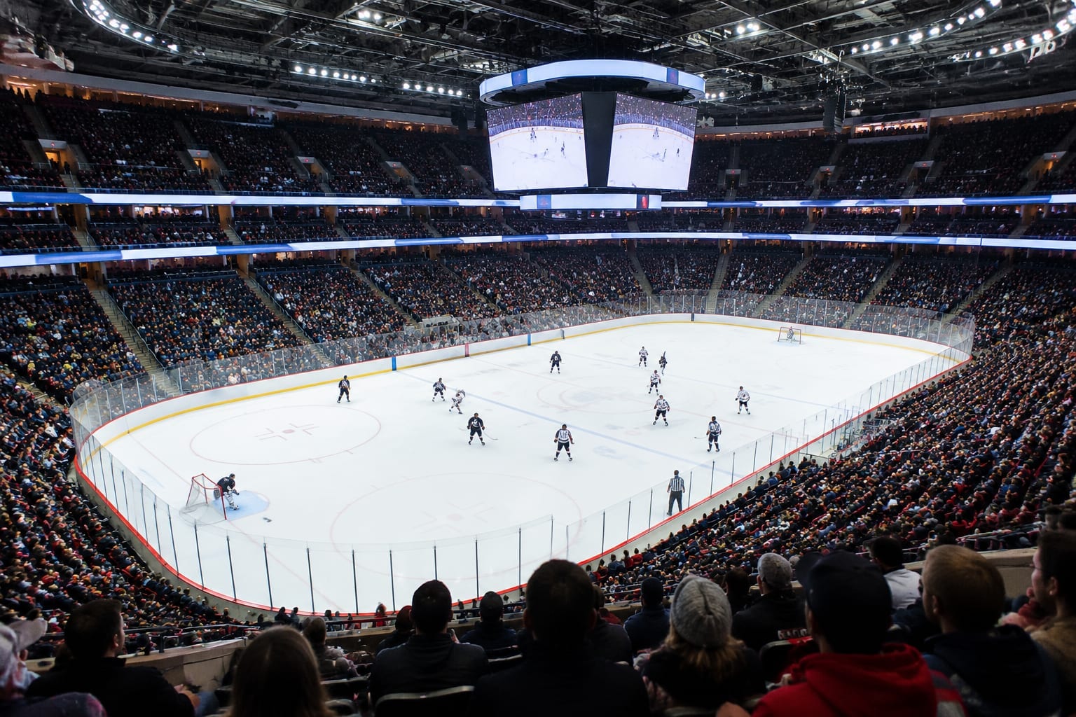 Packed professional hockey arena during a December game with fans in the stands
