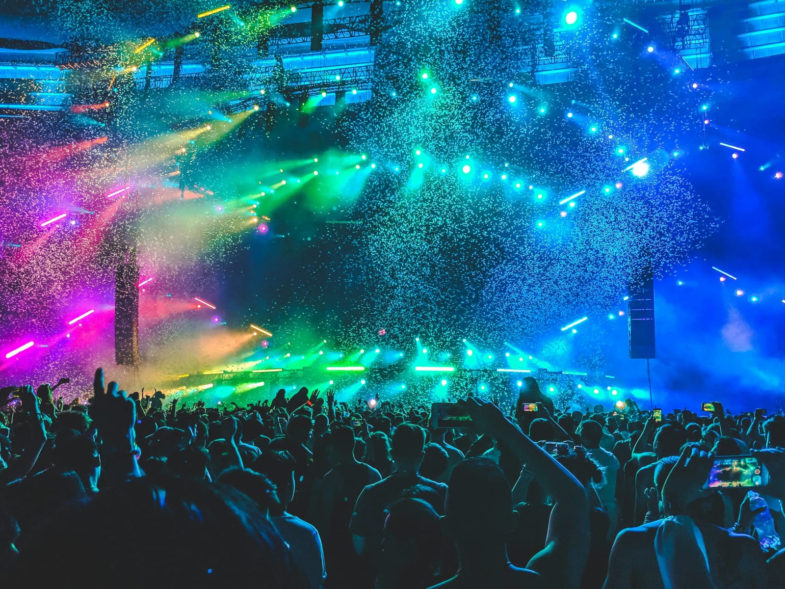 Evening concert scene with colorful stage lights and enthusiastic audience.