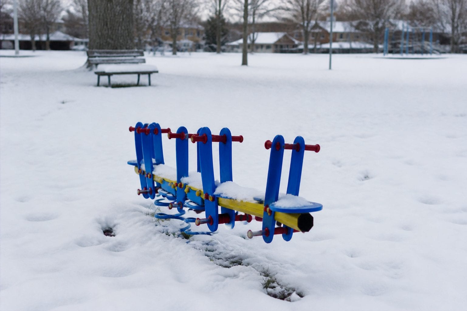 Families at a playground in changing seasons