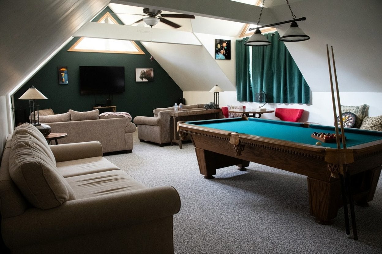 Row of pool tables under overhead lights