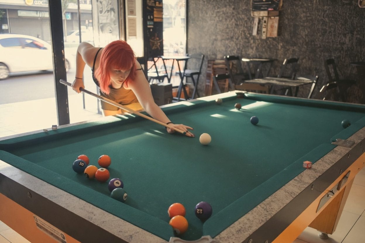 Players lining up a shot on a pool table