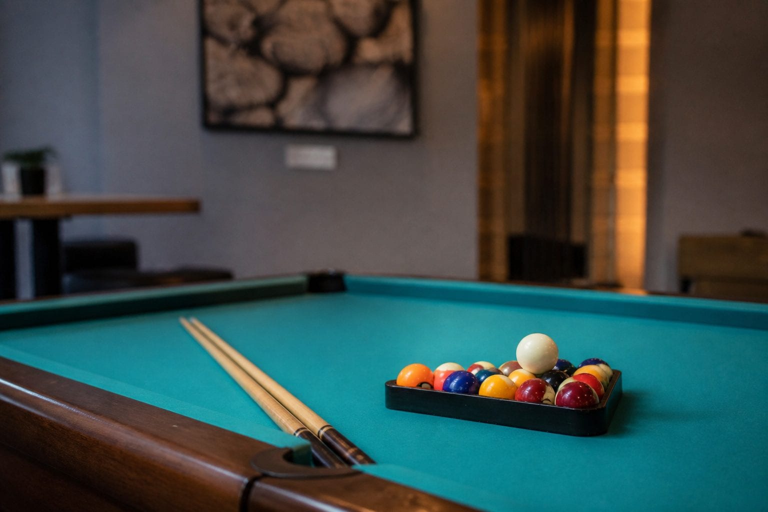 Pool balls and cues set up on a felt table