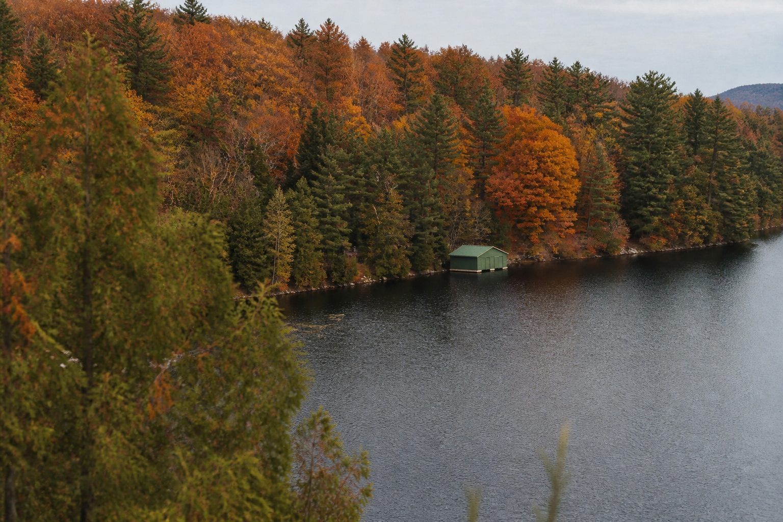 Cabin on a lake surrounded by autumn forest in Gatineau Park Quebec