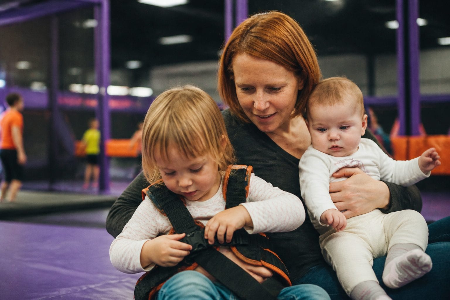 Family at trampoline park with safety gear