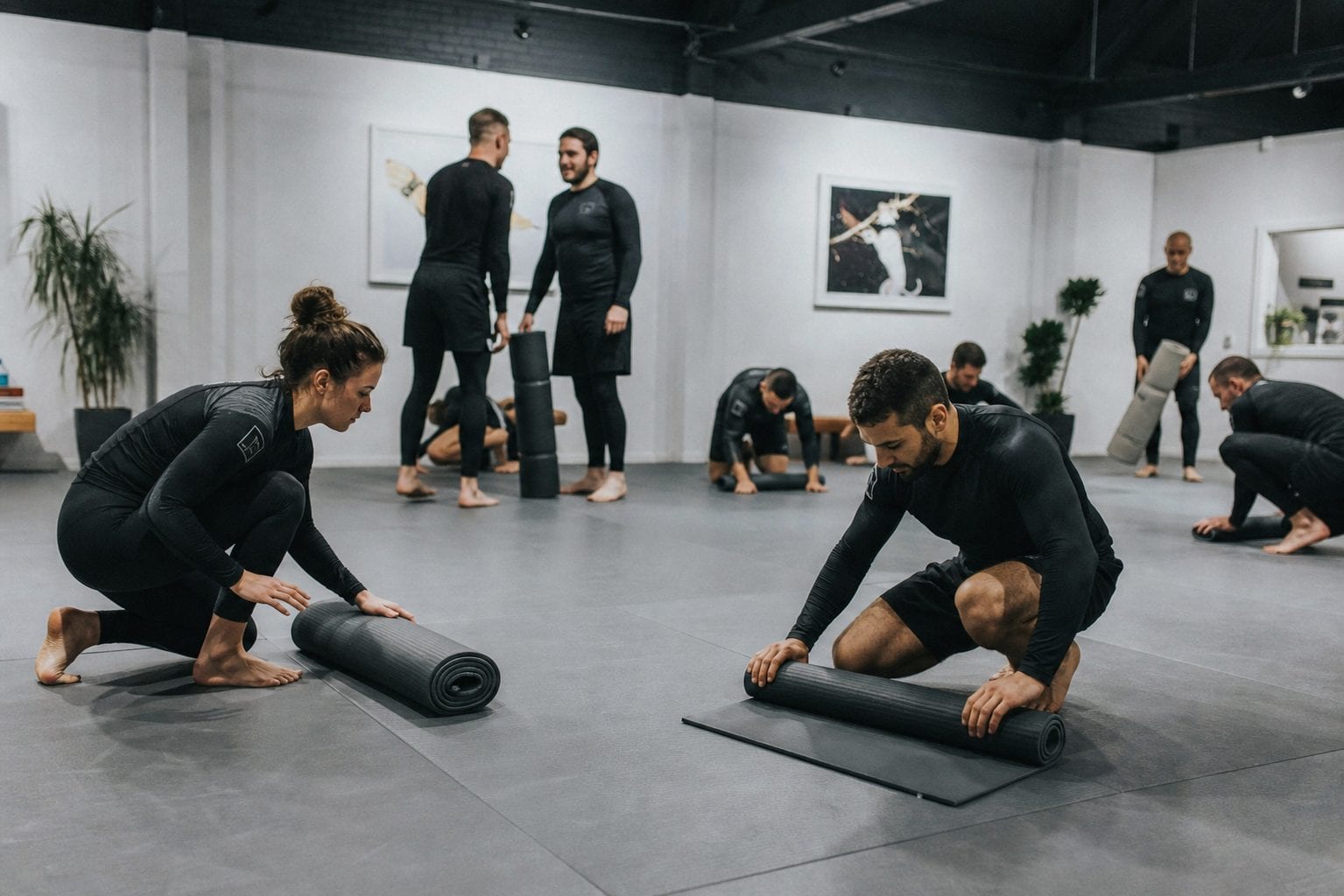 Students rolling up mats after class in a calm studio